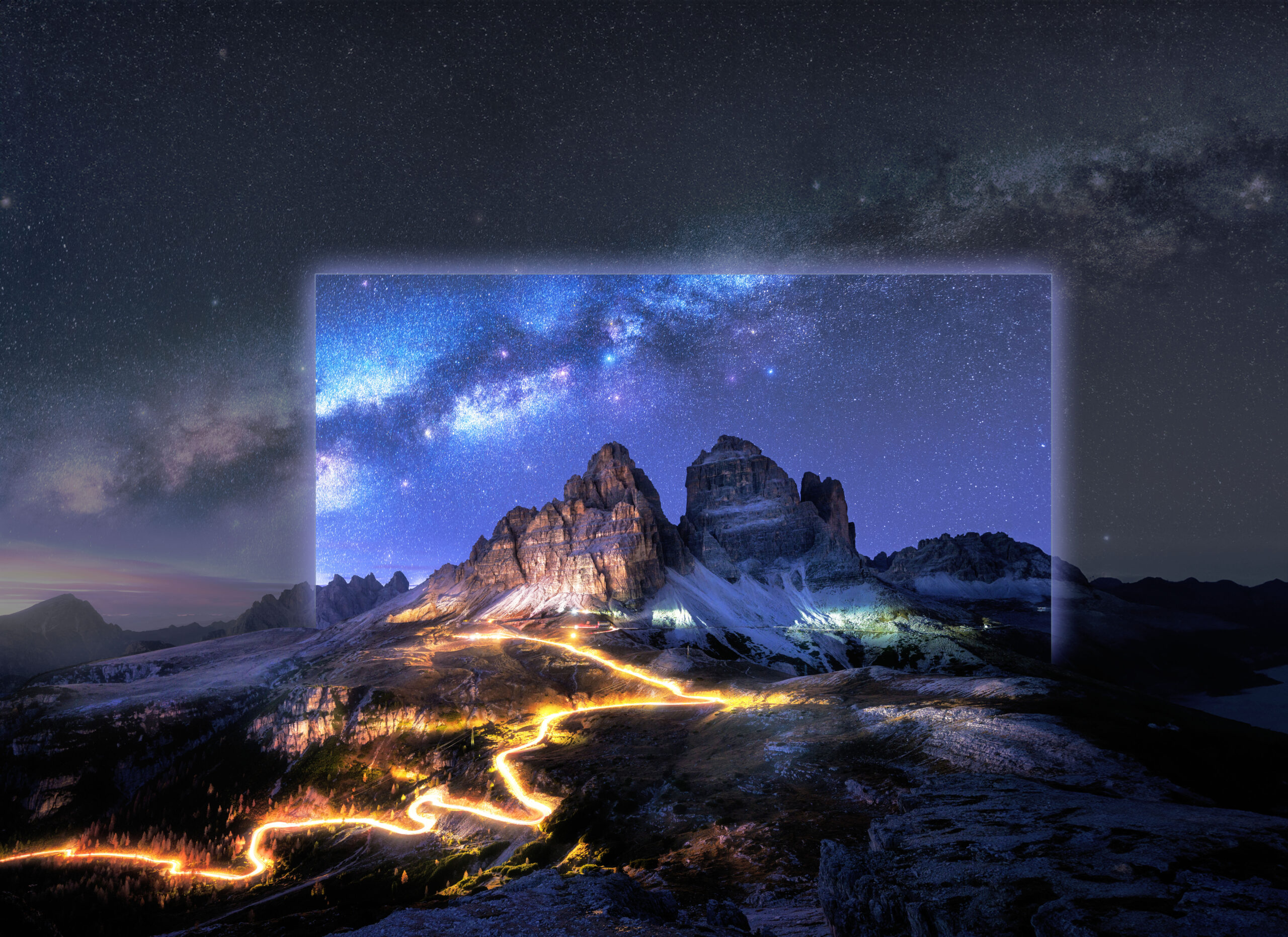 Milky Way, car light trails on mountain road at starry night